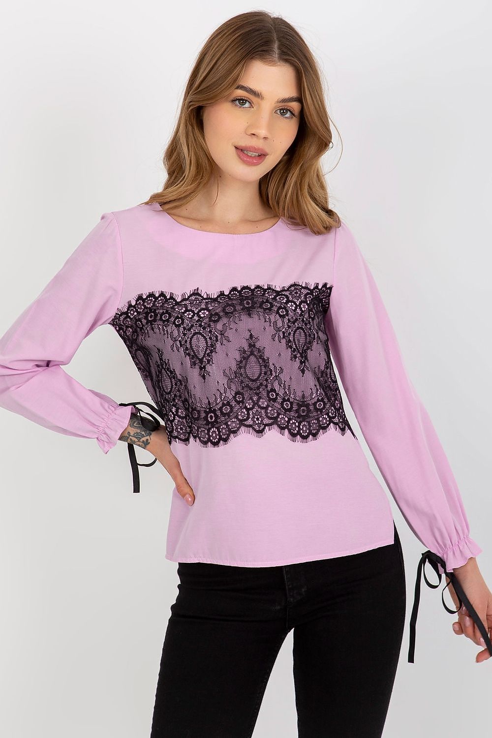 Sophisticated pink blouse with decorative black lace, perfect for any occasion, model posing confidently.