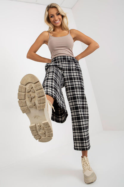 A playful view of Lakerta women's checkered wool trousers shows off their stylish wide-leg cut, complemented by a casual tank top and trendy footwear, perfect for a contemporary look.