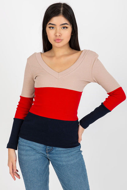 Elegant model showcasing a luxury ribbed blouse with a heart neckline and long sleeves in a stylish colour block design of beige, red, and navy, perfect for sophisticated casual wear.