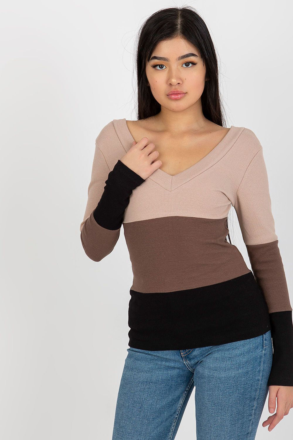 Beautiful model presenting a luxury ribbed blouse with long sleeves and heart neckline in a sophisticated earthy colour palette of beige, brown, and black, tailored for a modern aesthetic.