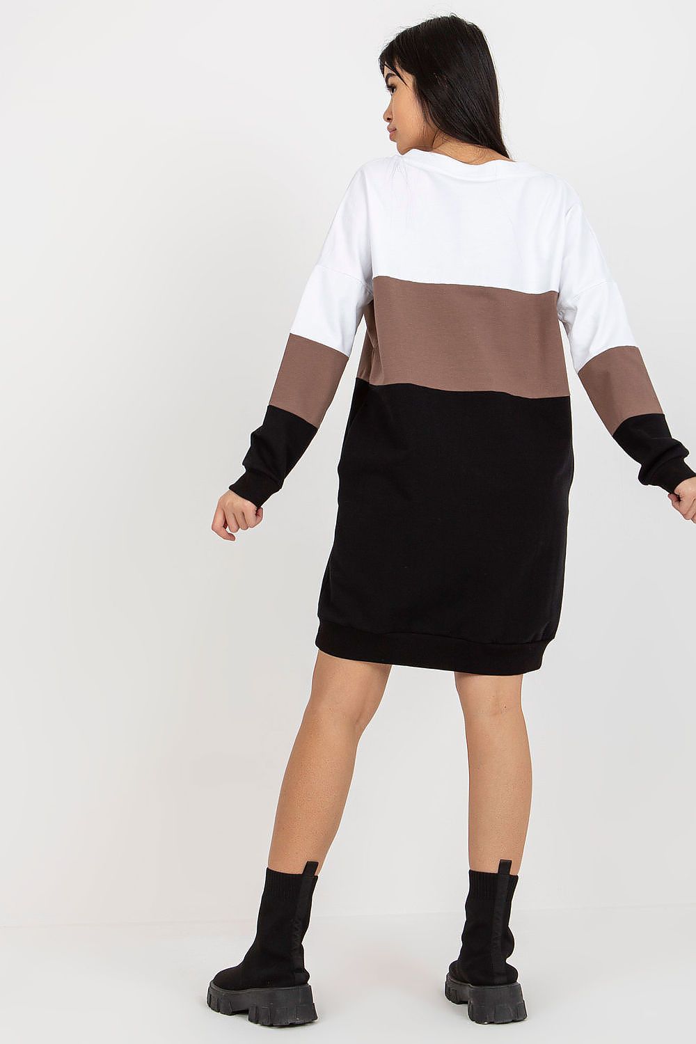 Back view of a luxurious Rue Paris tracksuit dress, highlighting its contemporary colourblock design in white, brown, and black. The model stands confidently, embodying effortless style with elegance.