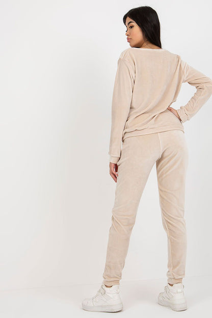 Sophisticated view of a beige velour outfit from the back, highlighting the comfortable long-sleeve blouse and tapered pants with stylish pockets.