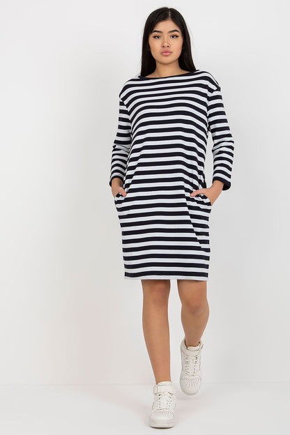 Chic black and white striped cotton dress with long sleeves by Rue Paris, complemented by stylish white sneakers, exuding a modern elegance.