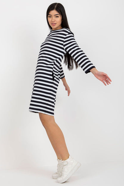 Sophisticated side view of a black and white striped long sleeve dress by Rue Paris, highlighting its relaxed fit and casual charm.