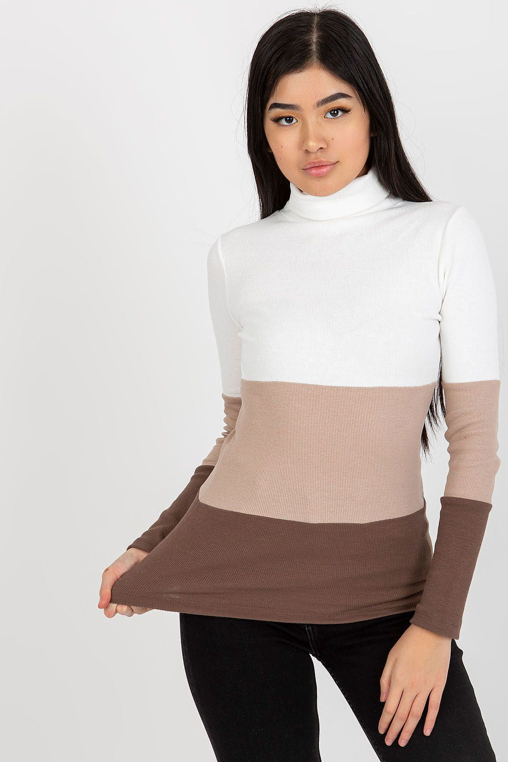 Model presenting luxurious ribbed turtleneck sweater in cream and brown, highlighting a chic front view.