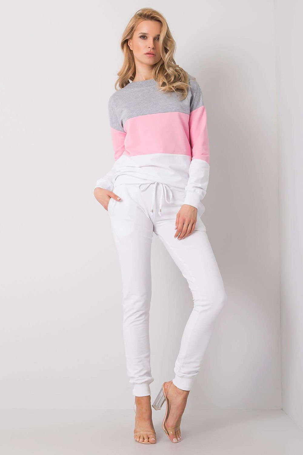 Fashionable model presenting a luxury cotton sweatshirt and jogger ensemble by Rue Paris, with a chic grey and pink colour-block design, perfect for stylish loungewear.