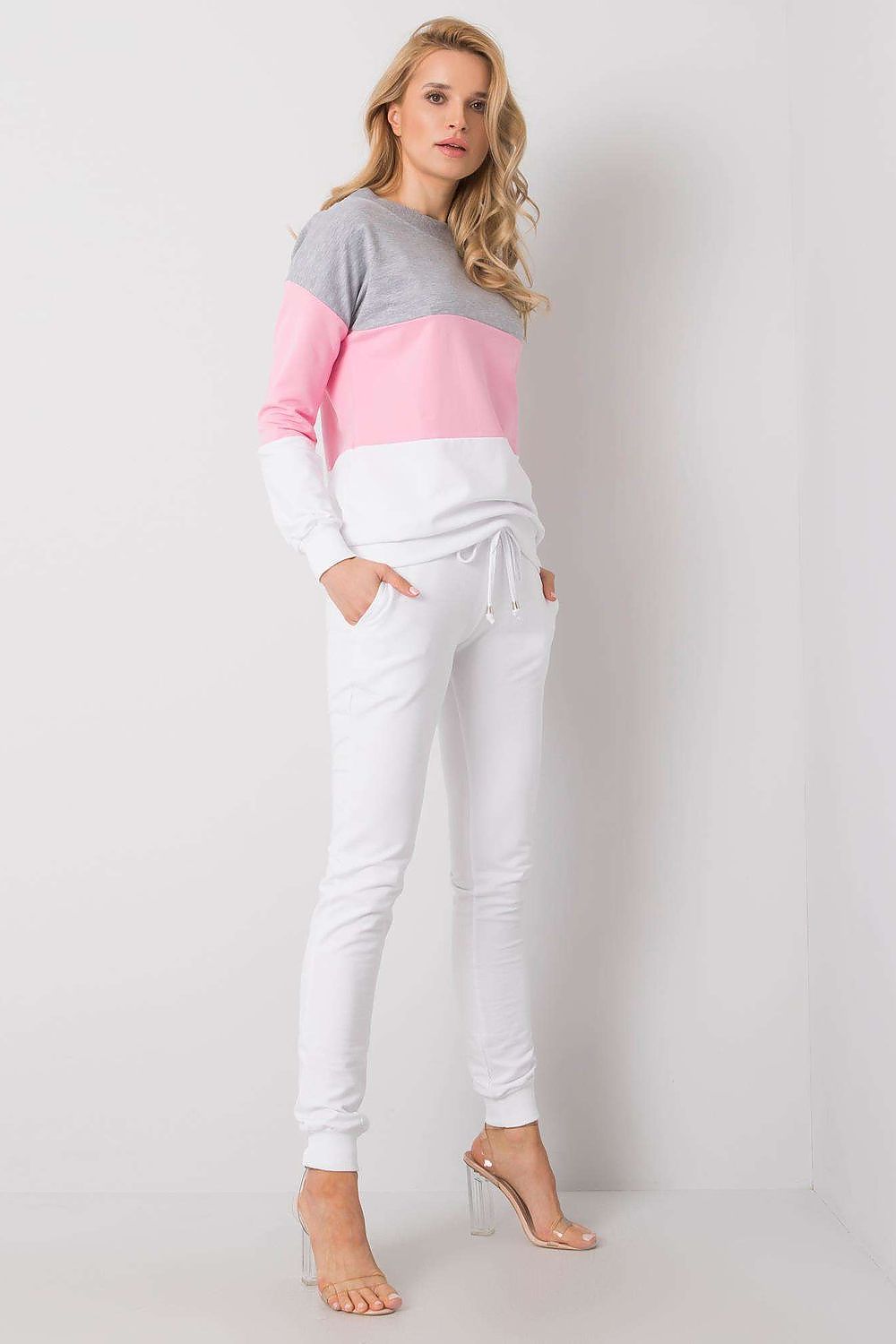 Side view of a model in a luxury 2-piece cotton sweatshirt and jogger set by Rue Paris, showcasing the elegant grey, pink, and white colour combination.