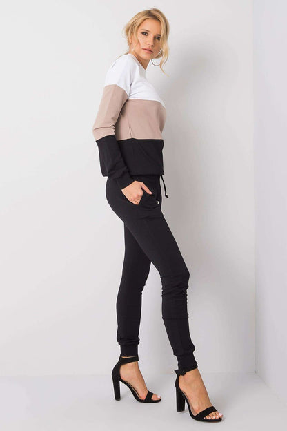 Side view of a model in a premium 2-piece ensemble by Rue Paris. The stylish cotton sweatshirt with contrasting colour blocks complements the sleek black jogger pants for a refined casual look.