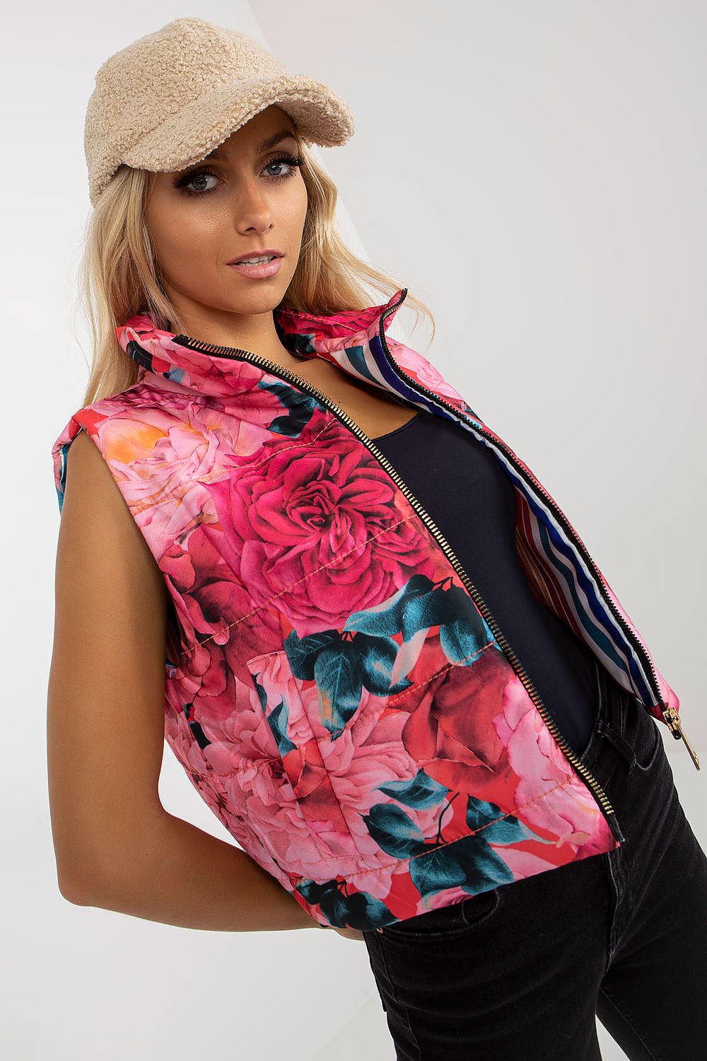 Elegant floral quilted insulated vest with pockets, modelled by a woman wearing a stylish cap, showcasing intricate rose patterns in vivid colours.