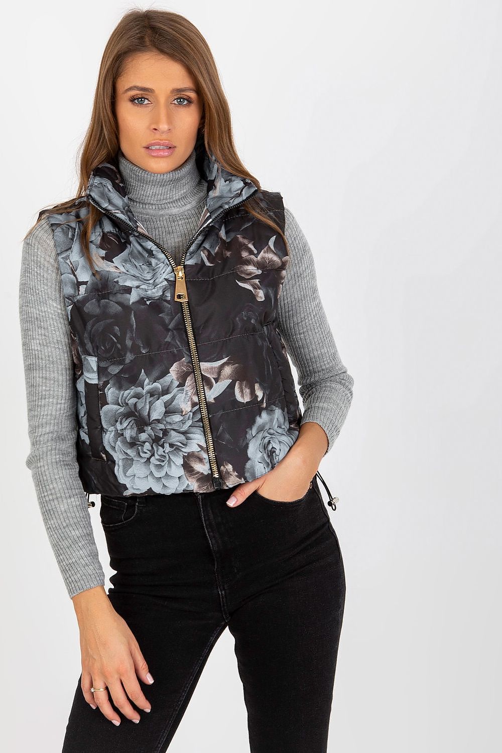 Elegant floral quilted insulated vest with pockets, styled with a turtleneck, perfect for chic winter layering.