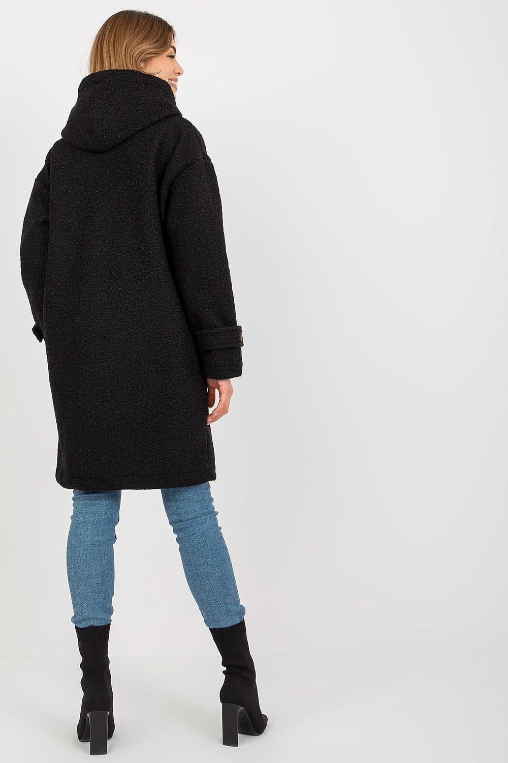 Sophisticated black plush coat with a cozy hood, model displaying the back view to emphasise the coat's luxurious design.