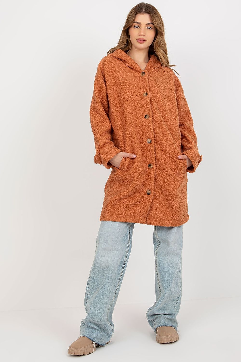 Chic orange plush coat with button closure and hood, model standing confidently to showcase its stylish appeal.