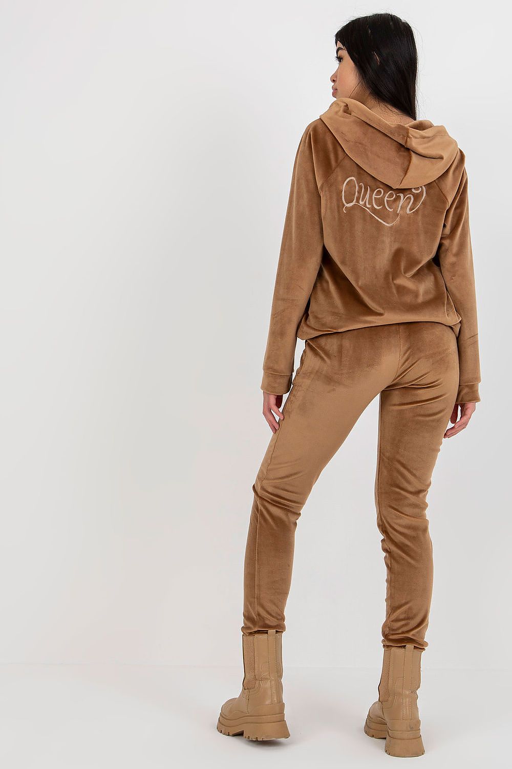 Elegant ladies' velour sweatshirt and pants set in a rich brown hue, featuring an embroidered 'Queen' motif, styled with a relaxed fit hood, complemented by form-fitting trousers, perfect for luxury leisure.
