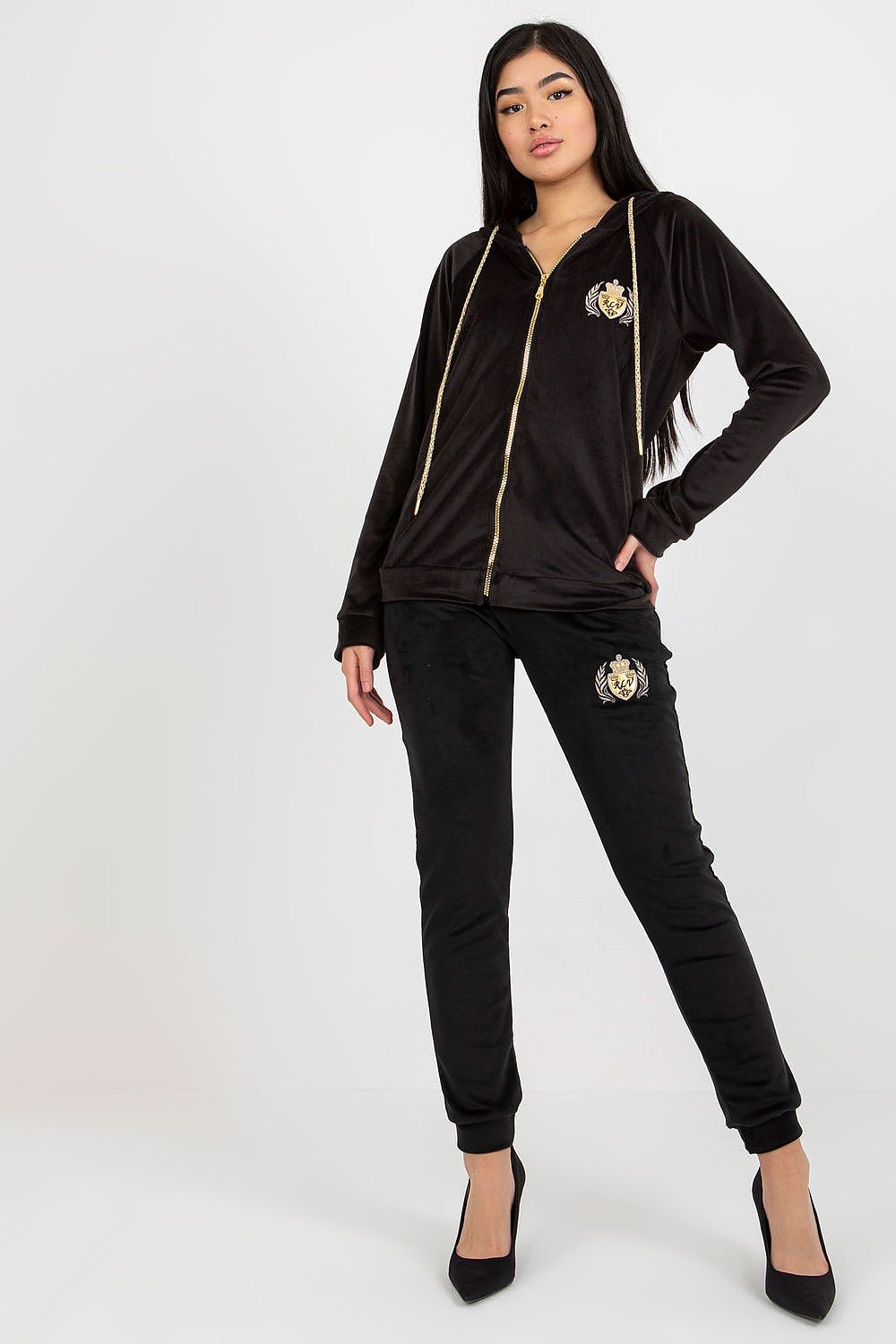 Luxurious black velour tracksuit for women, showcasing a zip-up hoodie adorned with a stylish emblem, paired with tailored pants, exuding sophistication and comfort for chic casual wear.