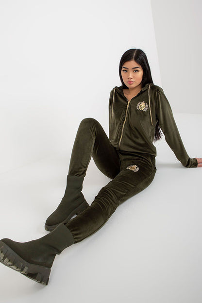 Stylish women’s velvet tracksuit in deep green, showcasing a zip hoodie with a striking emblem, combined with figure-flattering trousers, representing the perfect balance of fashion and luxury.
