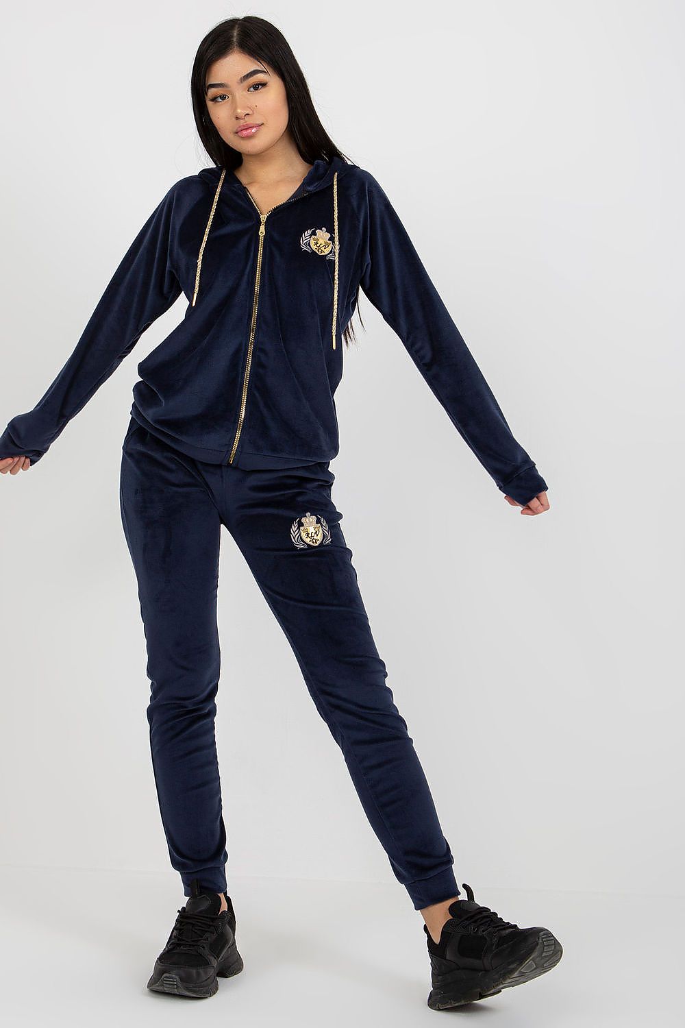 Luxurious navy velour sweatshirt and trousers set, highlighted by elegant embroidery, posed in a graceful manner to accentuate the ensemble.