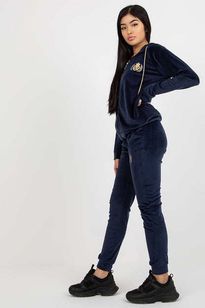 Stylish ladies' velour tracksuit in navy, featuring fashionable embroidery on both hoodie and pants, model displaying confidence.