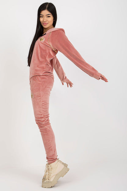 Fashionable side view of a plush velour ladies' tracksuit, highlighting the exquisite fit and soft fabric in a muted pink shade, perfect for an upscale loungewear collection.