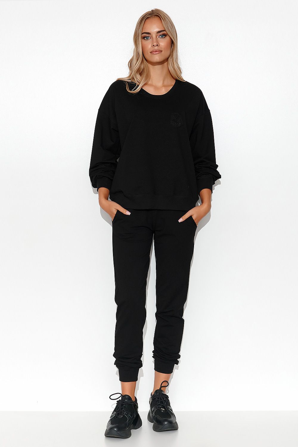 Luxury Women's Lightweight Knit Sweatshirt and Pants Set featuring ribbed cuffs and a collarbones reveal, elegantly styled in a modern setting.