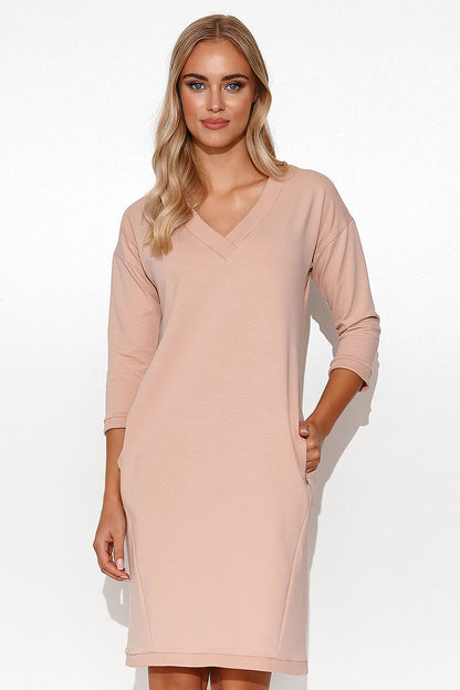 Model wearing the Stylish Makadamia Tracksuit Dress with V-Neck, 3/4 Sleeves and Pockets, epitomising luxury and relaxation for summer events.