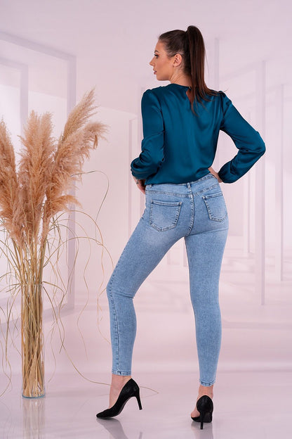 Back view of an elegant woman wearing the Merribel Satin Long Sleeve Blouse, highlighting the exquisite design and flattering fit in teal.