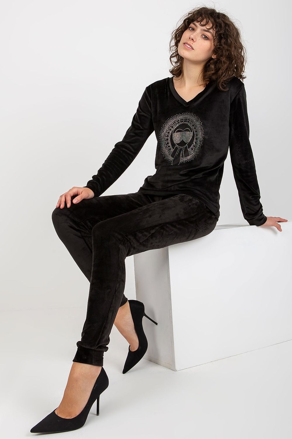 Elegant black velour blouse and pants set featuring a heart neckline design, styled with high heels, by Relevance.