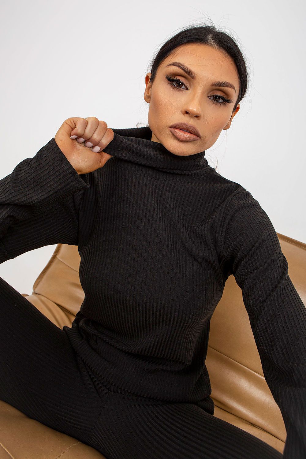 Close-up portrait of a woman in a luxurious black ribbed turtleneck blouse by Lakerta, showcasing a chic and modern aesthetic.