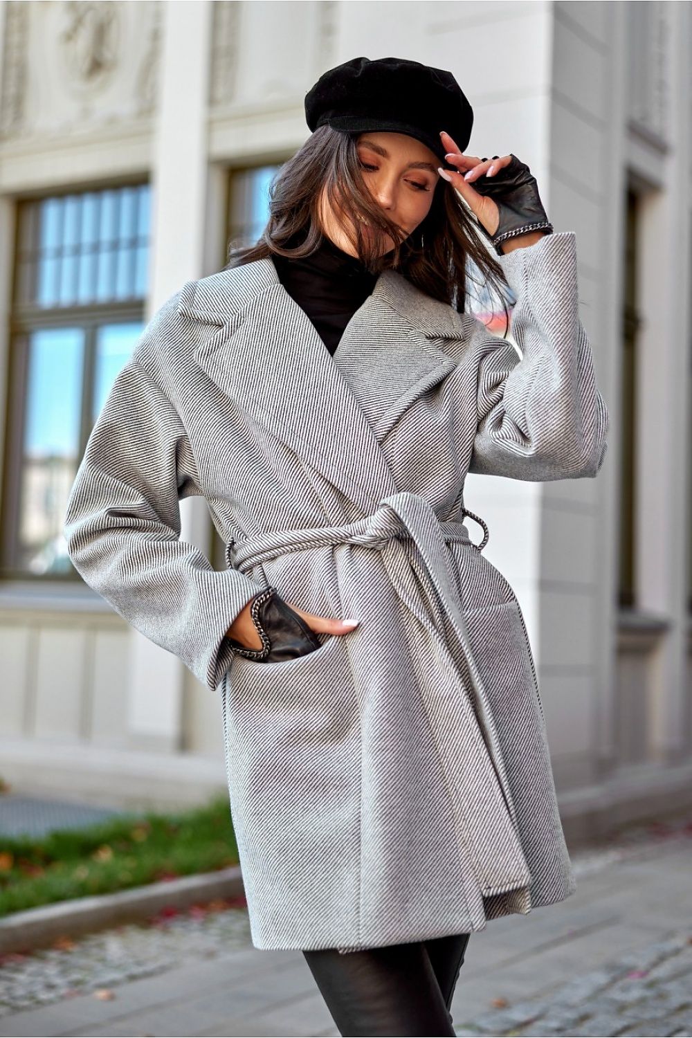 Elegant woman in a mid-thigh wool blend coat from Roco Fashion, featuring a sophisticated lapel collar and stylish flap pockets, capturing a chic outdoor look.