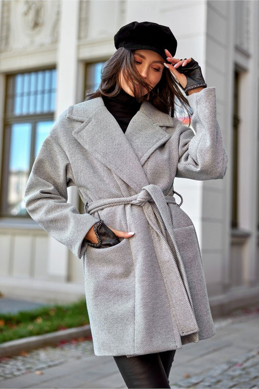 Elegant woman in a mid-thigh wool blend coat from Roco Fashion, featuring a sophisticated lapel collar and stylish flap pockets, capturing a chic outdoor look.