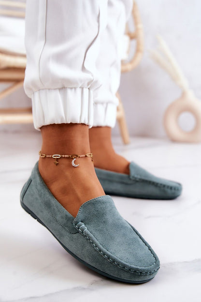 Close-up of luxury suede moccasins in soft blue, elegantly accessorised, highlighting sophisticated design by Step in Style.
