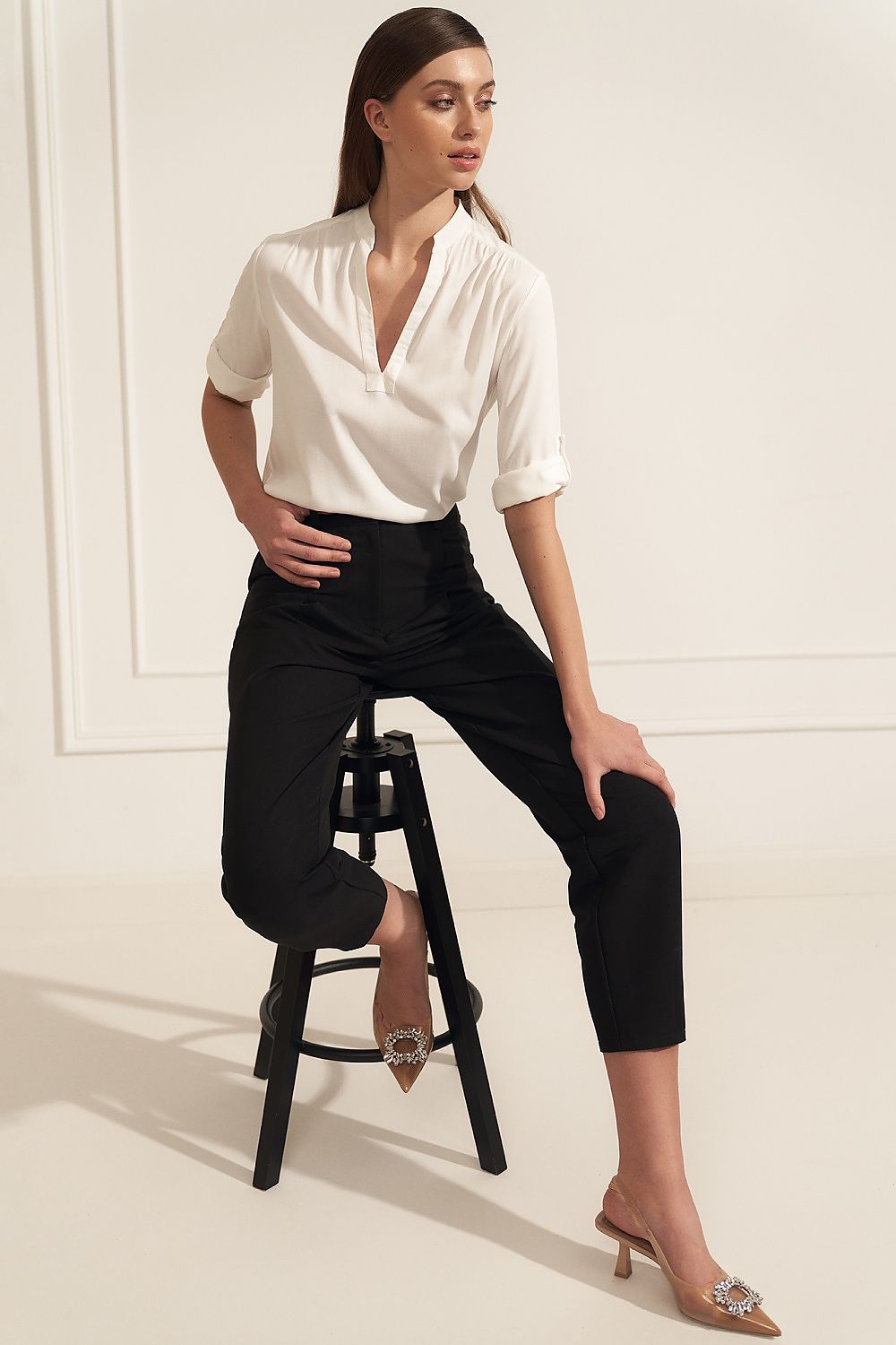 Elegant Nife high-quality viscose blouse styled with high-waisted black trousers, featuring a unique neckline and rolled up sleeves, perfect for sophisticated office attire.
