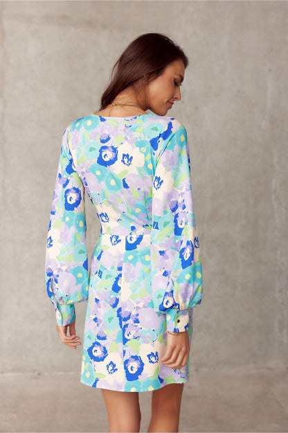 Back view of the exquisite Roco Fashion mini cocktail dress, showcasing the stylish long sleeves and flared hem, ideal for sophisticated celebrations.