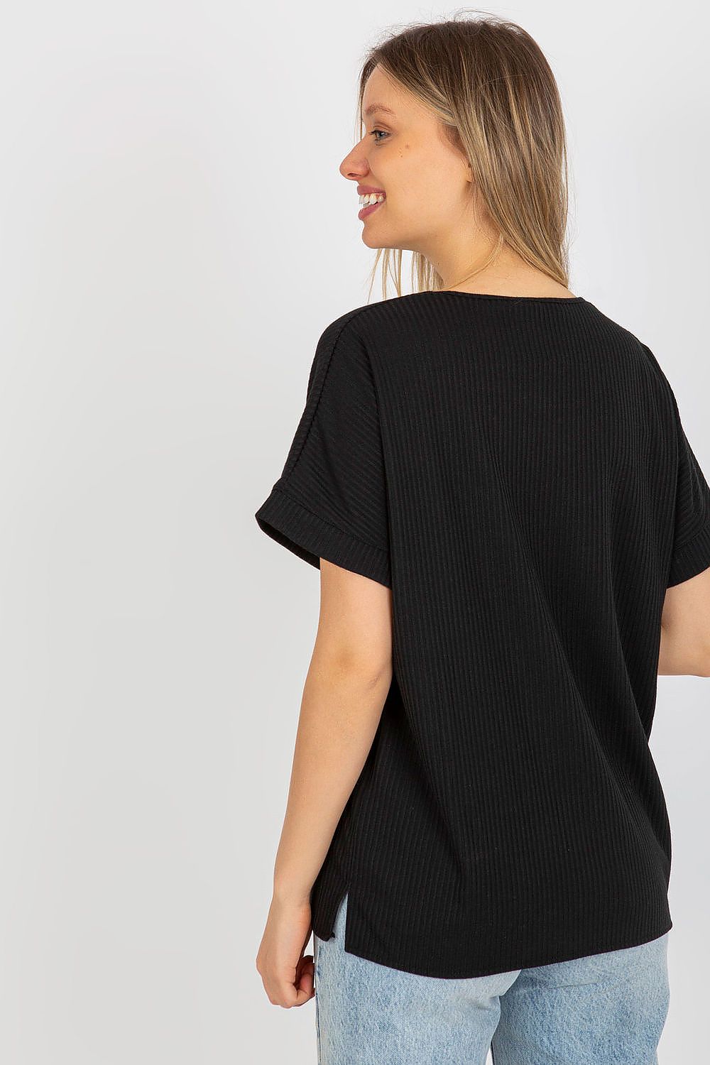 Back view of a luxury loose fit ribbed cotton blouse by Lakerta on a model, highlighting the elegant design and ribbed texture in sophisticated black.