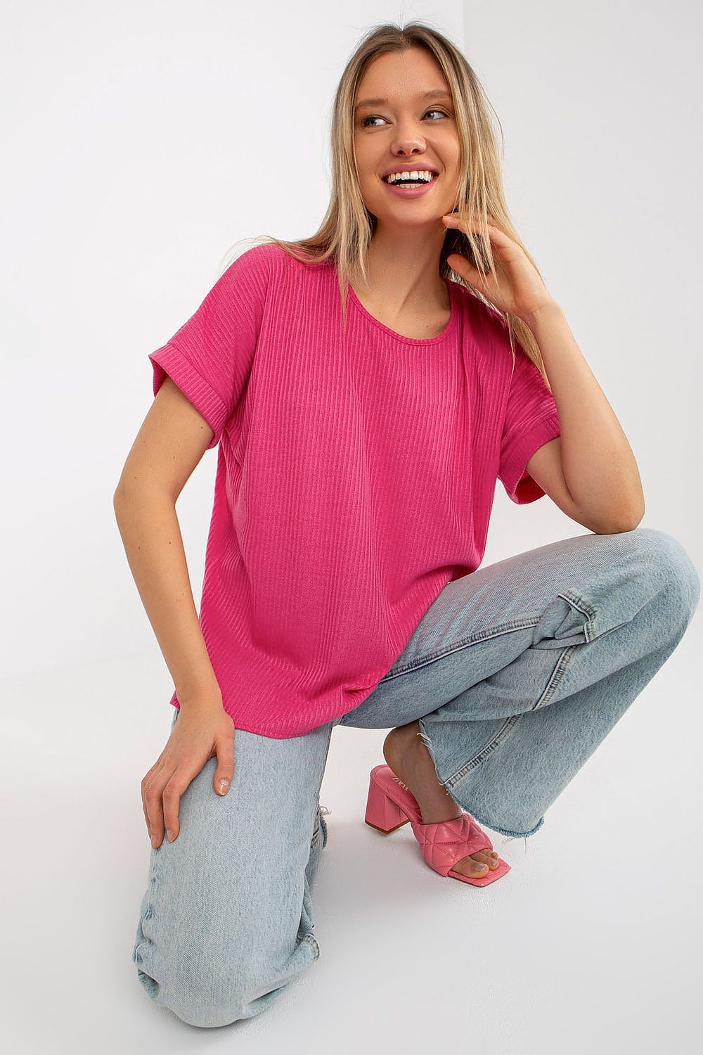 Chic pink ribbed blouse by Lakerta, showcasing a loose fit and short sleeves, styled for a fashionable and comfortable look suitable for any casual occasion.