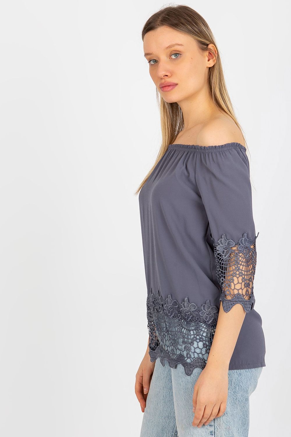 Chic side view of a model wearing the Elegant Lakerta Blouse, featuring intricate lace detailing and a flattering Spanish neckline, perfect for refined stylish occasions.