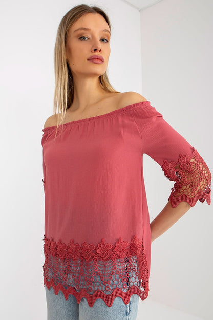 Stylish Lakerta blouse in soft coral hue with a delicate Spanish neckline and lace embellishments, showcasing luxury and elegance.