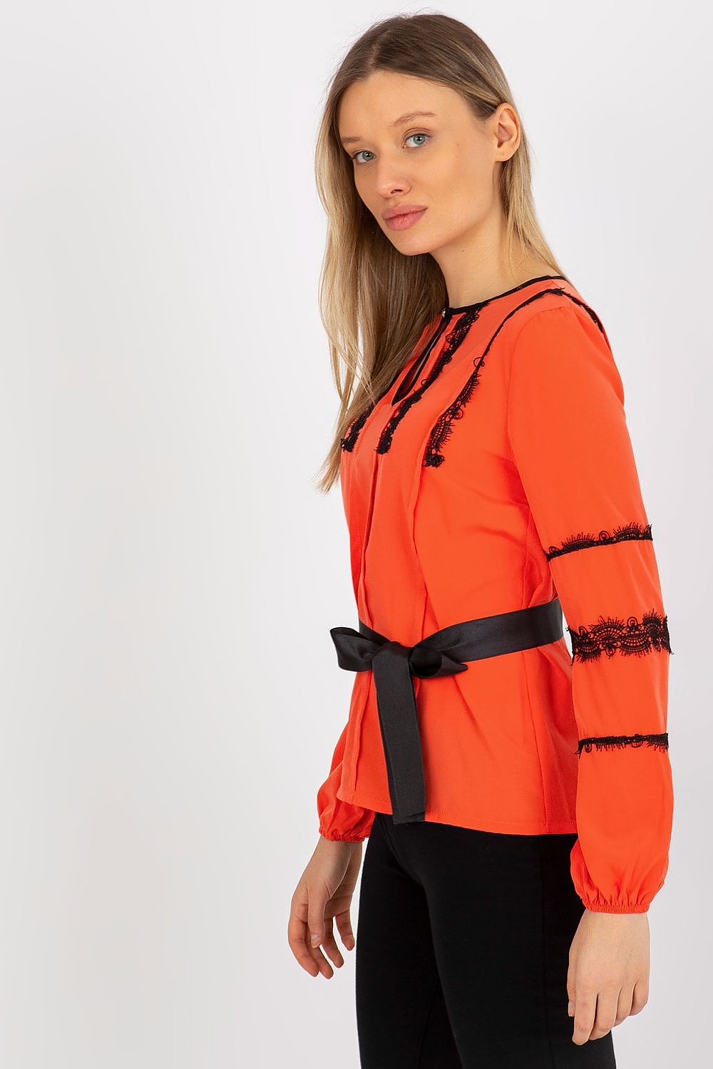 Profile view of an exquisite Lakerta orange long sleeve blouse, featuring delicate lace accents and a coordinating tie belt for women.