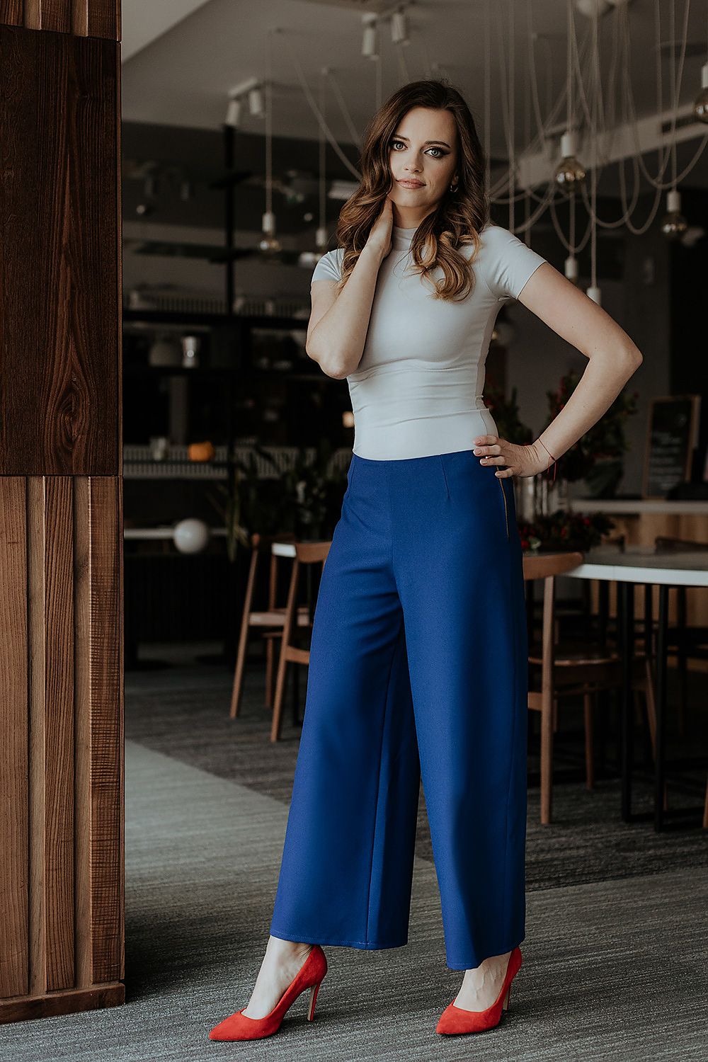 Model wearing Tessita's elegant 7/8 wide leg trousers with decorative zipper, demonstrating versatile styling options for modern women.