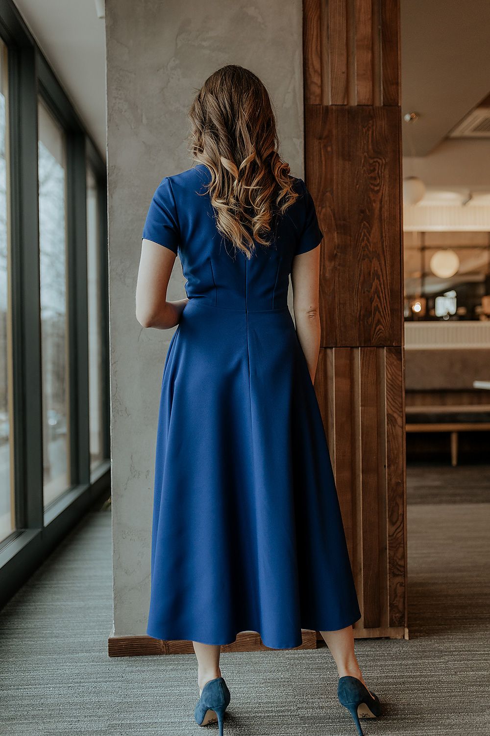 Model wearing the Tessita long dress with short sleeves, elegantly styled for a formal event or special occasion.