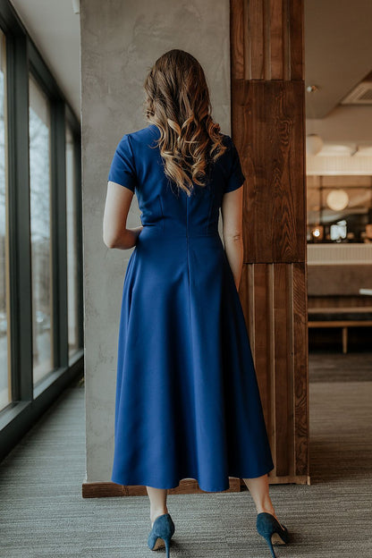 Model wearing the Tessita long dress with short sleeves, elegantly styled for a formal event or special occasion.