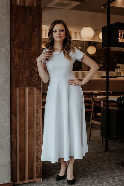 Tessita luxurious long dress showcasing a flared design and short sleeves, perfect for a chic evening event.