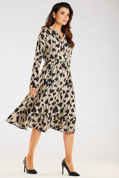 Elegant Awama midi dress featuring long sleeves, a distinctive neckline, and a flared frill hem. Styled in a sophisticated beige and black leaf pattern, perfect for chic everyday wear.
