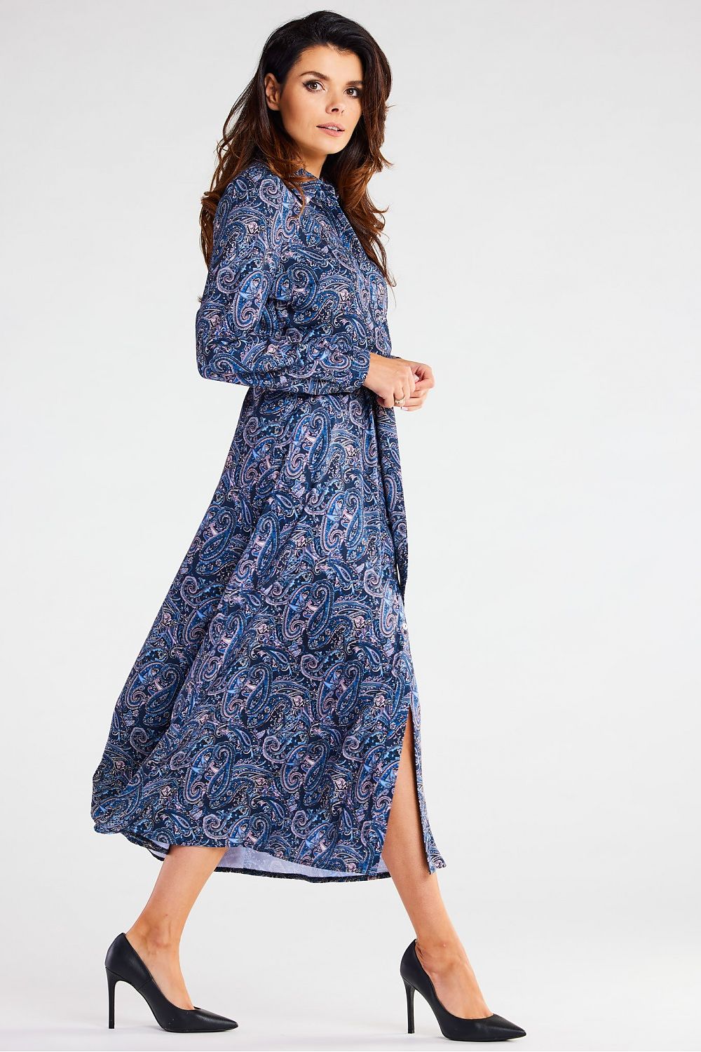 Fashionable model in an Awama maxi dress with long sleeves, adorned with a vibrant paisley print, gracefully walking to highlight the dress's flow.
