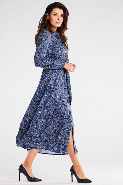 Fashionable model in an Awama maxi dress with long sleeves, adorned with a vibrant paisley print, gracefully walking to highlight the dress's flow.