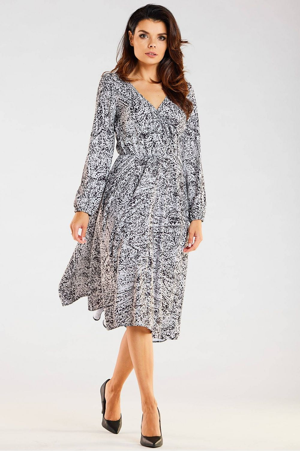 Elegant black and white midi dress by awama, exuding luxury with its flattering envelope neckline and flared design, presented by a poised model.