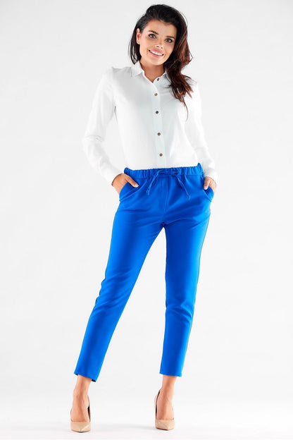 Chic front view of a model wearing vibrant blue casual trousers by Awama, perfectly paired with a classic white shirt and nude heels, embodying luxury in everyday fashion.