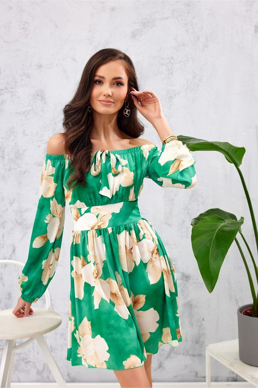 Elegant Roco Fashion Airy Mini Dress featuring a vibrant green design with floral patterns, open shoulders, and a flattering waist belt. The model showcases the dress's long buffed sleeves and stylish neckline in a sophisticated setting.