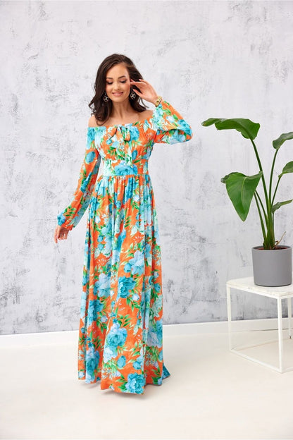 Stunning long Spanish maxi dress by Roco Fashion, showcasing an open shoulder style and eye-catching floral print in orange and turquoise, ideal for formal events.