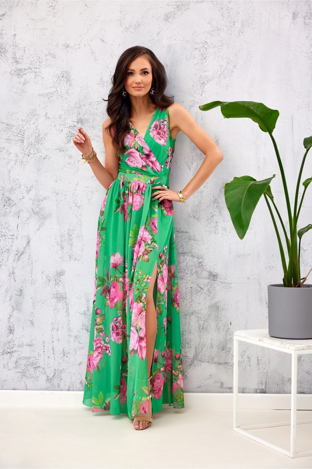 Elegant floral chiffon maxi dress by Roco Fashion featuring a vibrant green design, leg slit, and envelope neckline, styled for a sophisticated look.