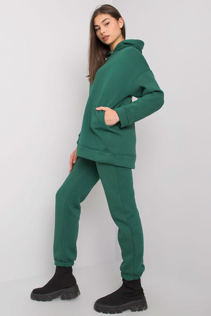 Chic model in a fashionable BFG velvety green sweatshirt set with hood, paired with tapered pants, exuding comfort and luxury.